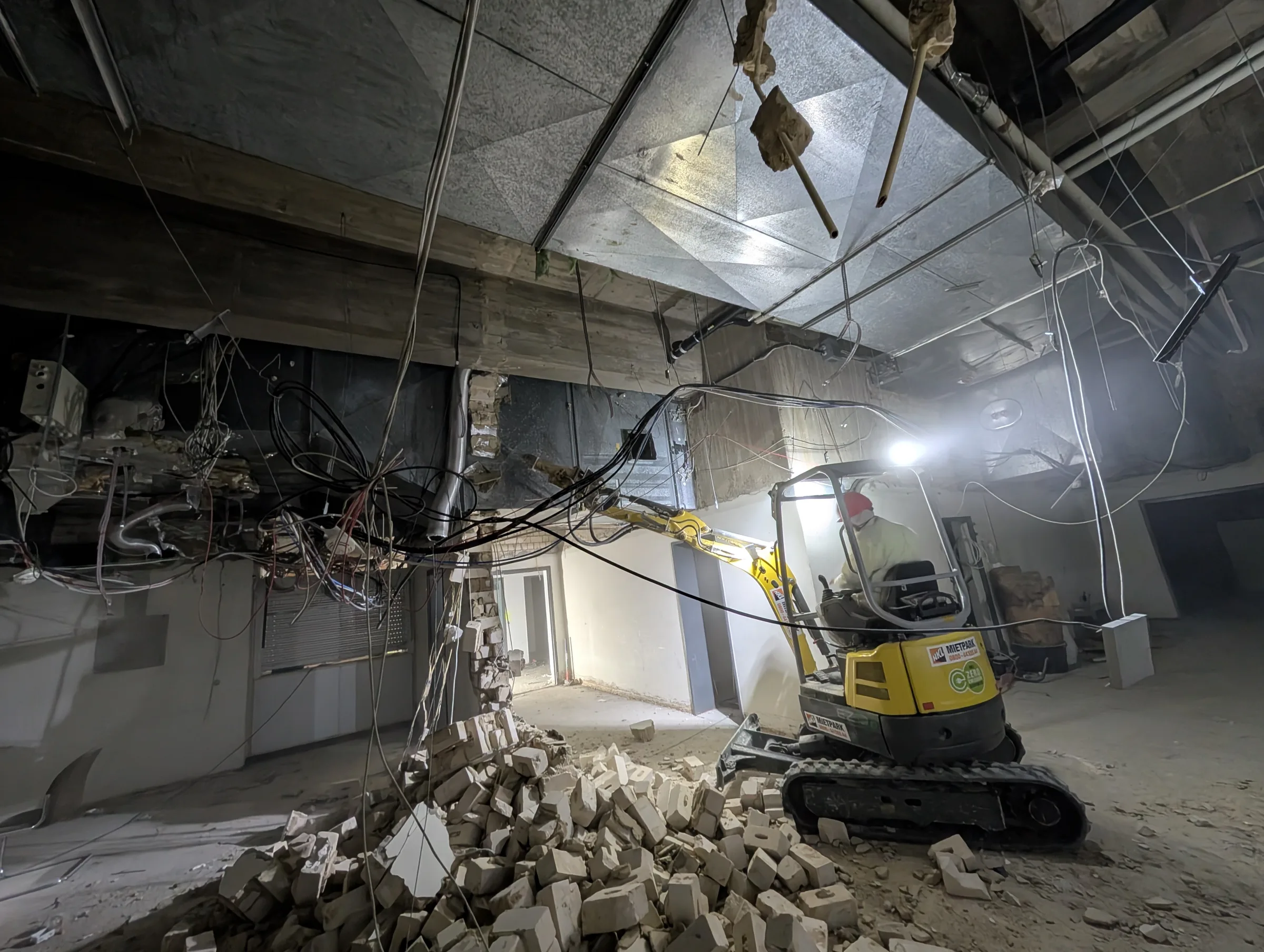 Mini-Bagger beim Innenabriss mit Schutt und entkernten Decken